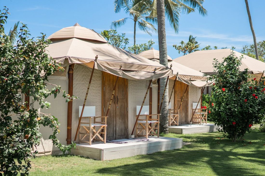 A row of glamping tents with deck chairs